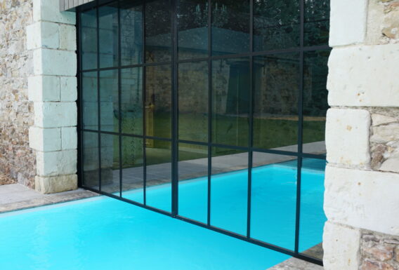 Piscine intérieure avec grande verrière noire type atelier ouvrant sur extérieur - Construction pisciniste Angers