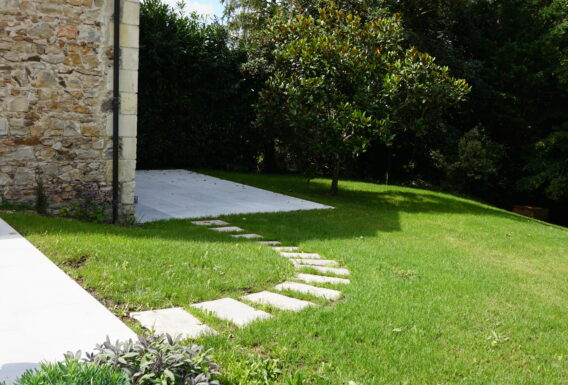 Allée en pas japonais et pelouse impeccable avec piscine et bâtiment en pierre - Aménagement paysagiste Saumur